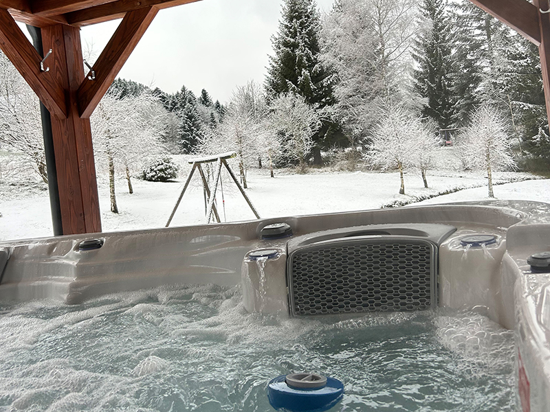Un spa extérieur abrité sous une pergola